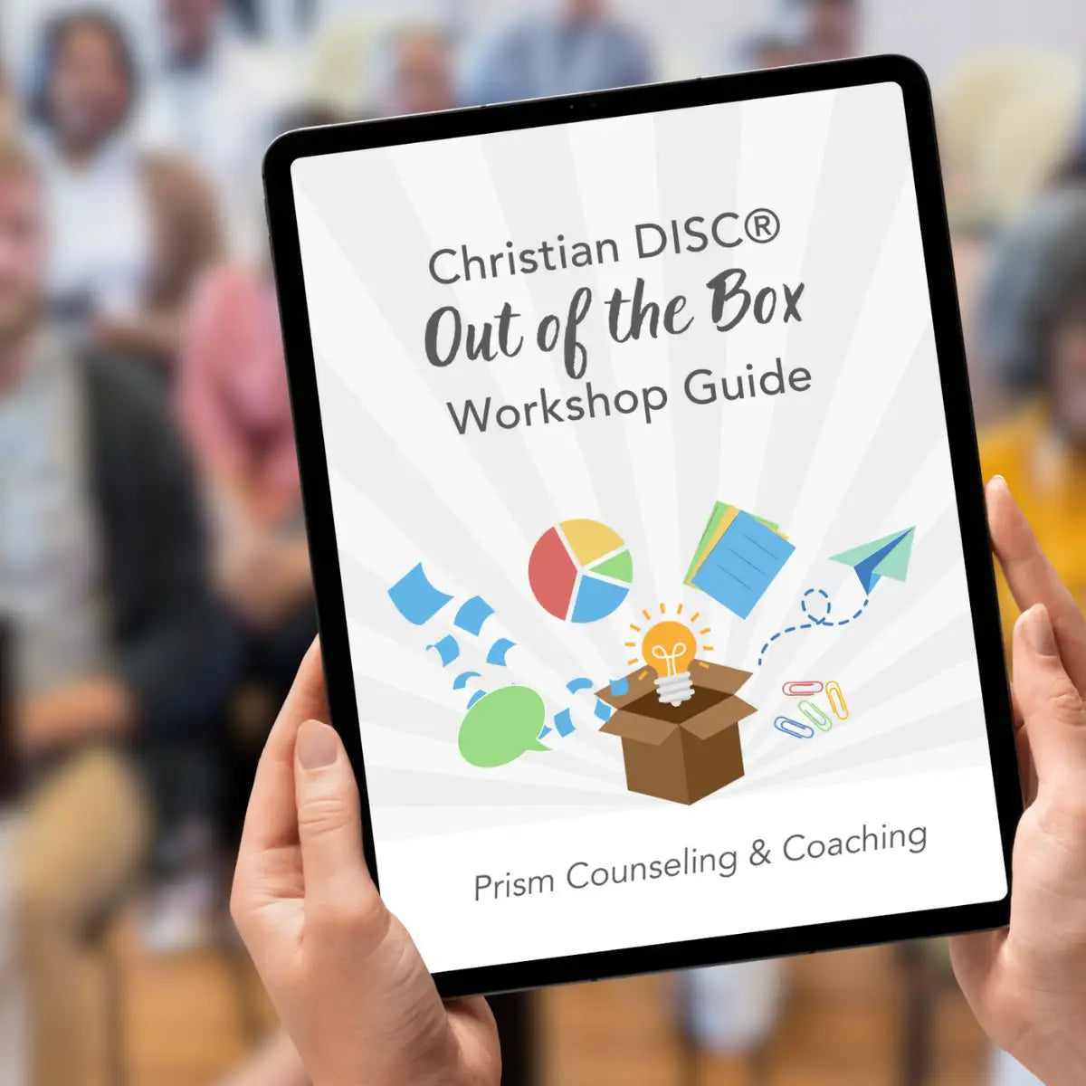 Black-framed tablet displaying a white cover for the ’christian disc® out of the box workshop guide’ by prism counseling & coaching, featuring colorful illustrations including an open box with a lightbulb and office supplies.