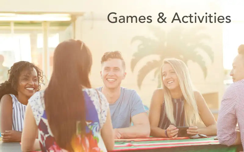Group of smiling friends gathered around a table for games and activities.