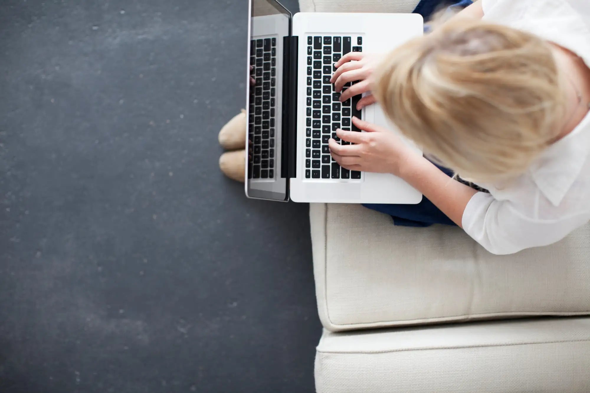 White laptop with black keyboard and trackpad, sleek aluminum chassis